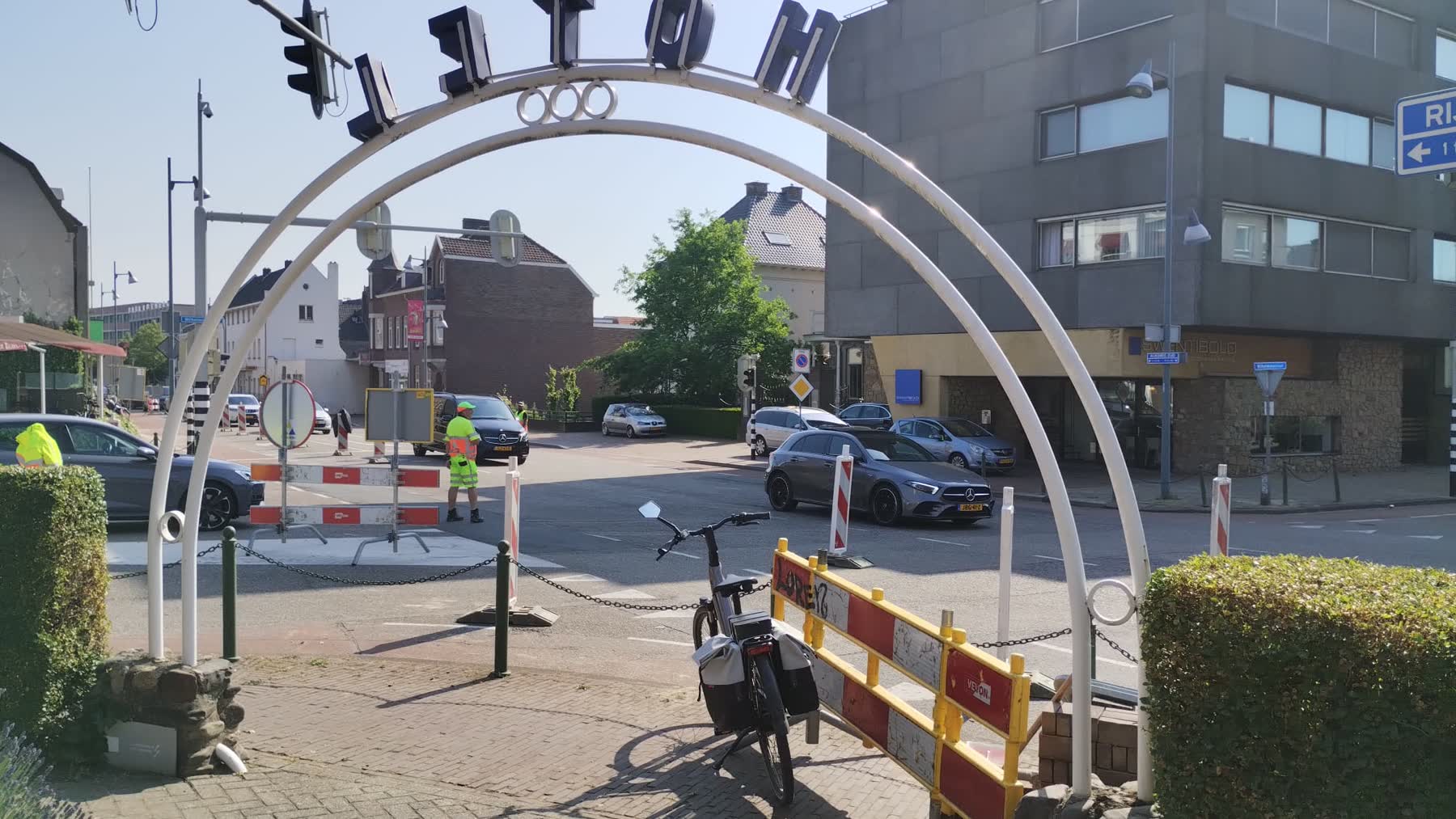 Verkeersregelaars begeleiden het verkeer op een kruispunt met afzethekken in een winkelgebied