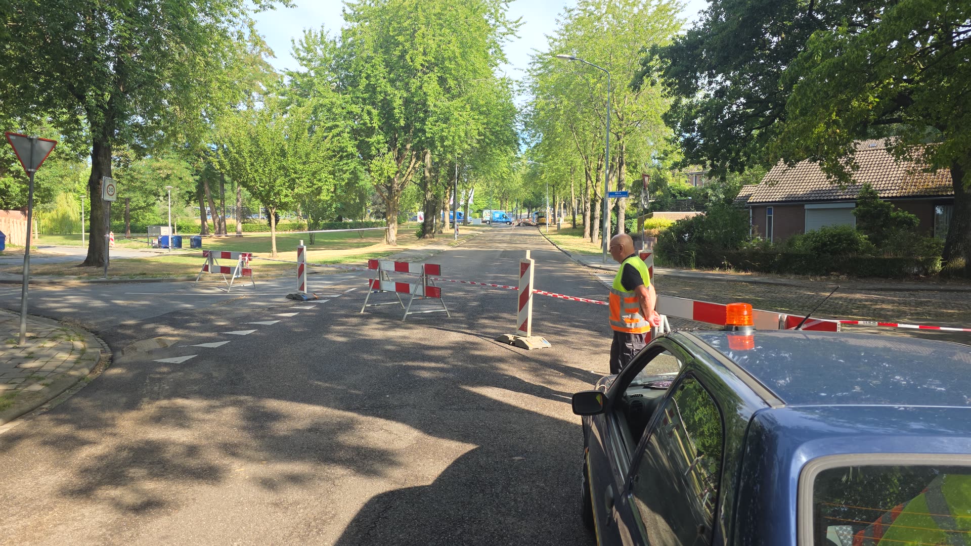 De volledig afgesloten laan in Hoensbroek, met dranghekken en afzetlint over de volle wegbreedte.